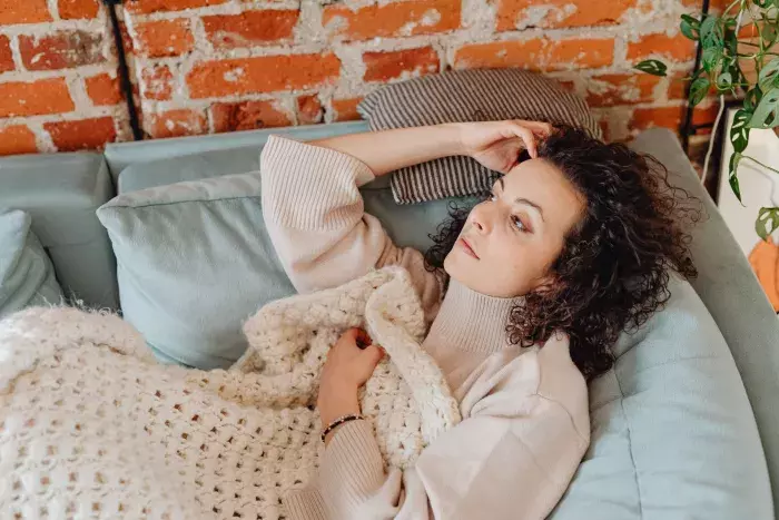 Femme allongée sur un canapé et pensive